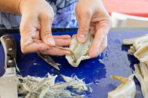 Cleaning the smelts, removing the spines