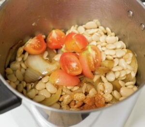 In the pot beans, tomatoes, onions