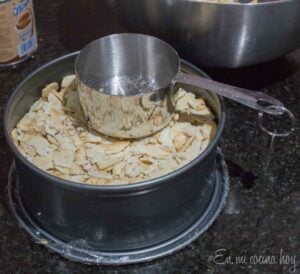 Filling the pan with layers of crumbs and dulce de leche.