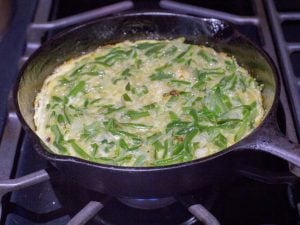 Cooking the tortilla de porotos verdes