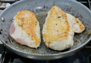 Cooking the other side of the chicken breast.