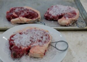 Salting the steaks.