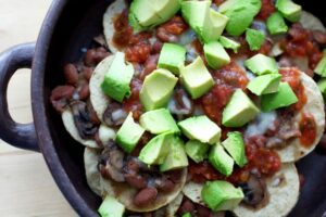 Topping the nachos with avocado.