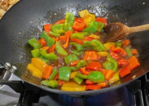 peppers on sauce on wok