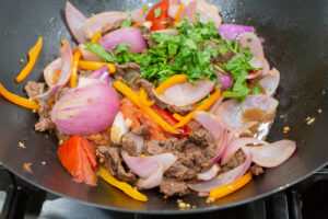 Finishing the lomo saltado with cilantro