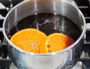 Orange slices in a pot of red wine.
